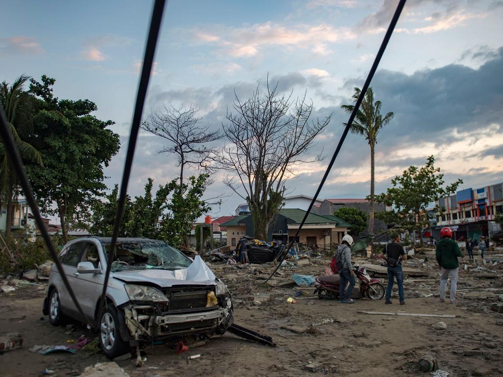 People view the damage to a beach. Picture: AFP