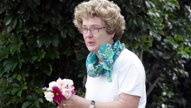 A distraught woman arrives with a bouquet of flowers to the scene of the murder of store owner Frank Newbery, 87, in Union Street, Newcastle.