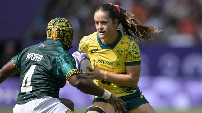 Australia's Dominique Du Toit (R) is chased by South Africa's Zintle Mpupha (L) during the women's pool B rugby sevens match between Australia and South Africa during the Paris 2024 Olympic Games at the Stade de France in Saint-Denis on July 28, 2024. (Photo by CARL DE SOUZA / AFP)