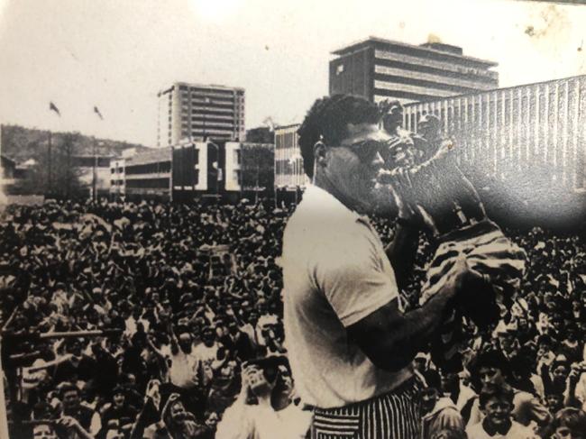 Raiders legend Mal Meninga covering the broken base of the 1989 Winfield Cup trophy with a towel.