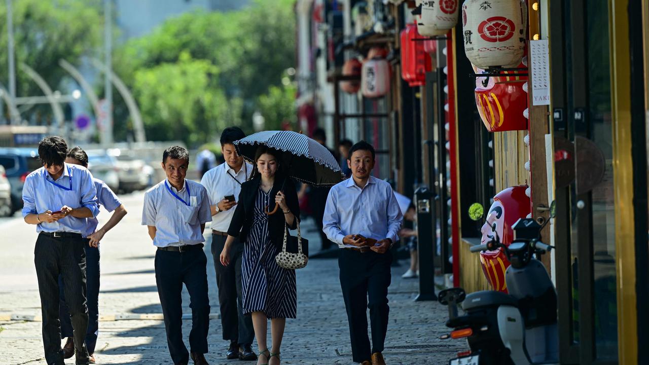 People walk past a Japanese restaurant near the Japanese embassy in Beijing. Picture: Pedro Pardo/AFP