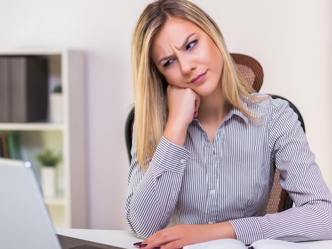 CAREERS: Angry businesswoman sitting in her office and working.