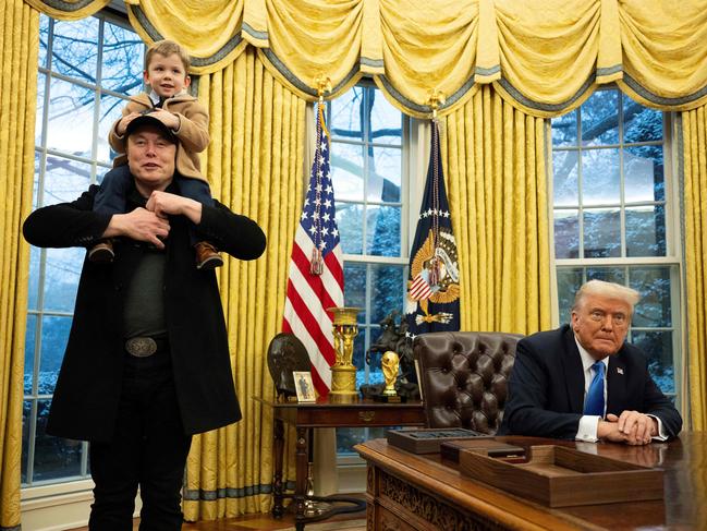 Elon Musk carries his son X Ã A-Xii on his shoulders while speaking as US President Donald Trump looks on in the Oval Office of the White House in Washington, DC, on February 11, 2025. Tech billionaire Elon Musk, who has been tapped by President Donald Trump to lead federal cost-cutting efforts, said the United States would go "bankrupt" without budget cuts. Musk leads the efforts under the newly created Department of Government Efficiency (DOGE), and was speaking at the White House with Trump, who has in recent weeks unleashed a flurry of orders aimed at slashing federal spending. (Photo by Jim WATSON / AFP)