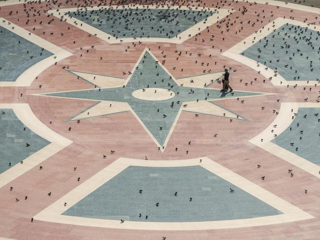 A tourist pushes his suitcase across an empty Catalunya square 20 in Barcelona, Spain. Picture: Getty Images