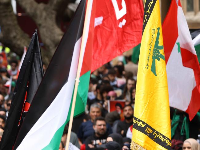 People hold up the yellow Hezbollah flag at a protest at Town Hall in Sydney Picture: NewsWire / Damian Shaw