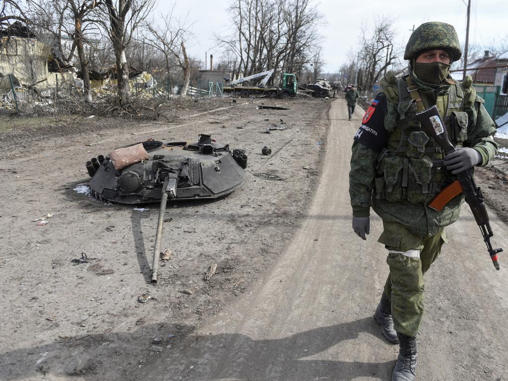 A service member of the self-proclaimed Donetsk People‘s Republic walks past a top turret of an armoured vehicle in the town of Volnovakha in the Donetsk region on March 13, 2022. Picture: Reuters/Stringer