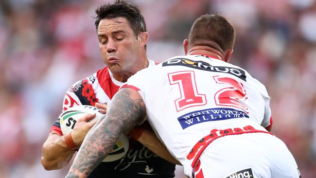 Cooper Cronk of the Roosters is tackled by Tariq Sims.