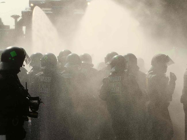 Policemen were hit by their own water cannons as they called desperately for reinforcement. Around 200 officers were sent as back up from other cities. Picture: AFP PHOTO / DPA / David Young / Germany OUT