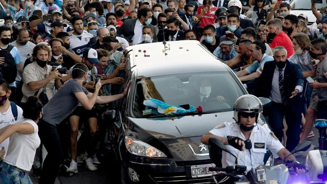 Fans mob Diego Maradona’s hearse as it leaves the presidential palace in Buenos Aires on Friday. Picture: AFP