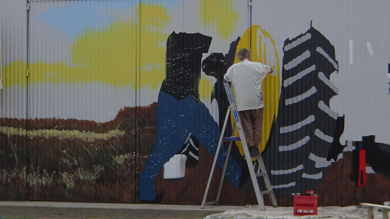 Work is underway on a mural on the shed of Condamine business Condamine Seeds and Tyre.
