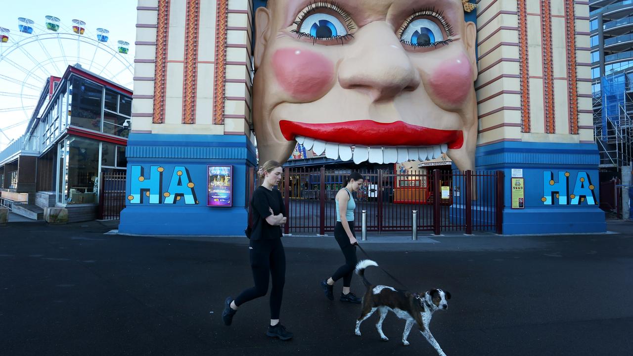Two women walk by the entrance to Luna Park on Friday during Greater Sydney's lockdown. Photo: Lisa Maree Williams/Getty Images