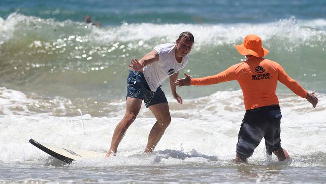 Former pro surfer Cheyne Horan giving Minister Steven Miles some surfing lessons at Burleigh Beach. Photo: Steve Holland