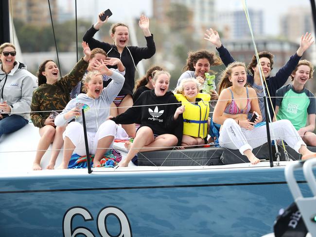 A group of young people on a boat wave to Prince Harry, Duke of Sussex and Meghan, Duchess of Sussex as they watch the Elliott 7 Team racing final during the Sailing on day two of the Invictus Games Sydney 2018. Picture: Getty