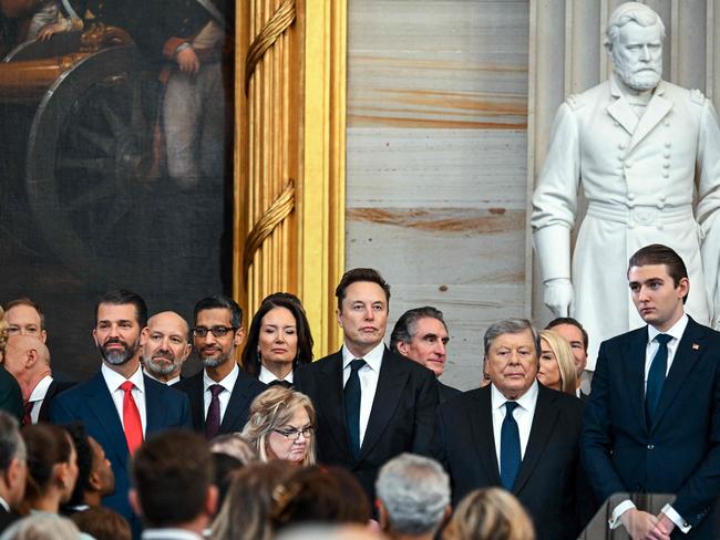 All the gang is here ... Elon Musk (centre) and Donald Trump’s son Barron Trump (right) with Donald Trump Jr and other members of the presidential coterie at the inauguration. Melania Trump and her hat are out of shot.