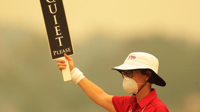 A golf marshal wears a face mask as smoke haze lingers during day one of the 2019 Australian Open. Picture: Mark Metcalfe/Getty Images