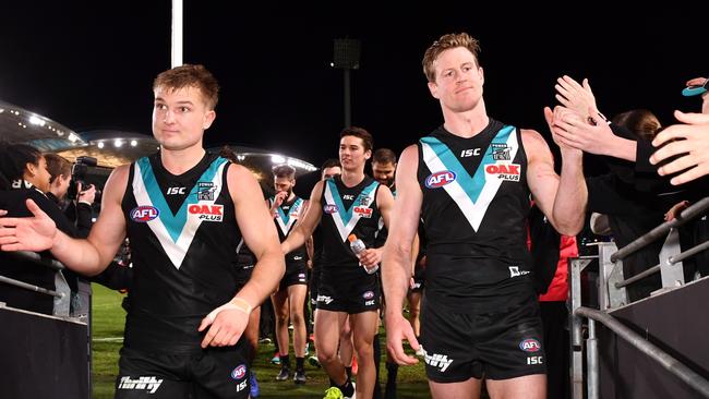 Port Adelaide co-captains Ollie Wines and Tom Jonas lead their team off the ground after the round 23 win over the Dockers at Adelaide Oval. Picture: Mark Brake/Getty Images