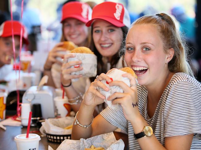 Tahlia Eaton, Sarah Madden, and Taelah Goodman, tuck into a burger at Carl's Jnr. Picture: Troy Snook