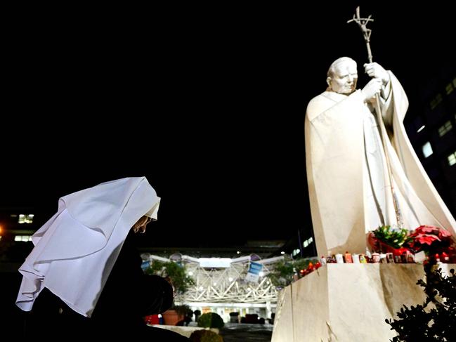 A nun prays in front of a statue of Pope John Paul II outside the Gemelli hospital where Pope Francis is hospitalised. Picture: Tiziana Fabi/AFP