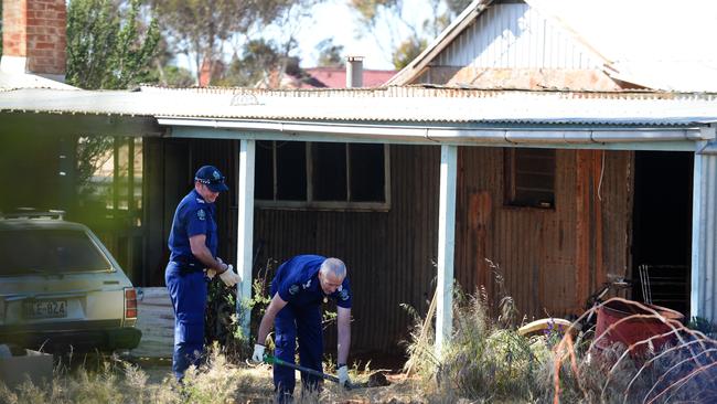 Police in the backyard of the property at Terowie, where the bones of Martin Meffert were found in a bag in the fireplace in 2013.