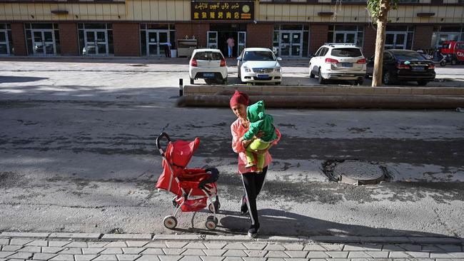 A woman walking in an ethnic Uighur neighbourhood in Aksu in Xinjiang. Picture: AFP