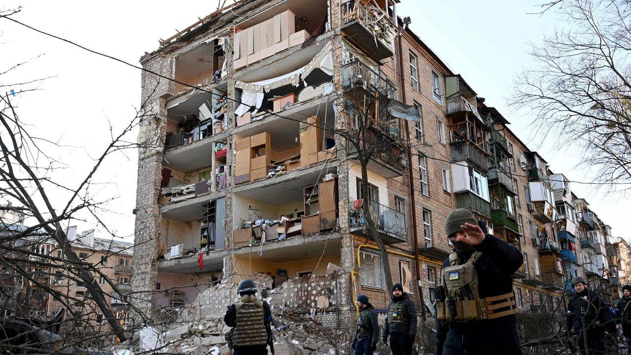 Ukrainian policemen secure the area by a five-storey residential building that partially collapsed after a shelling in Kyiv. Picture: AFP.