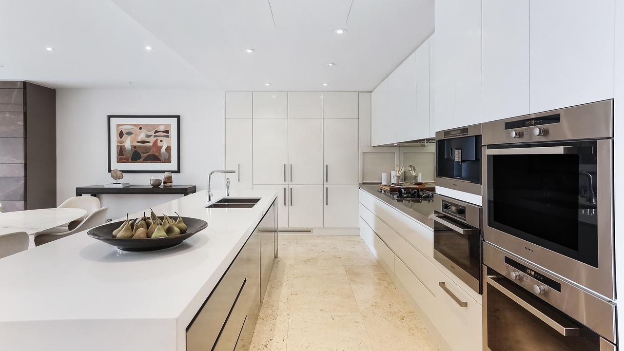 The kitchen has a large freestanding bench and Miele appliances.