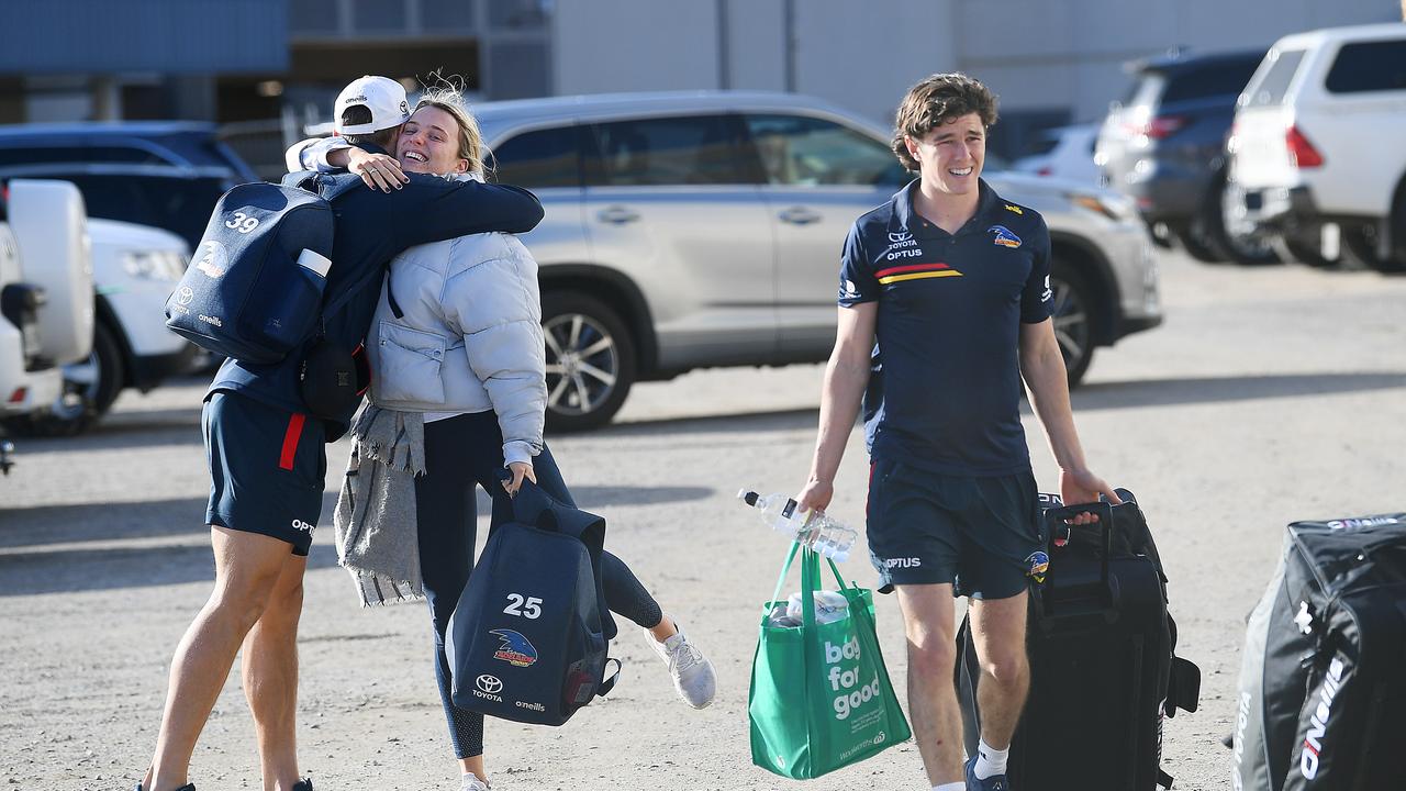 Tom Doedee of the Crows hugs Ned McHenry of the Crows girlfriend as they arrive at West Lakes to start their trip to Melbourne only to have it cancelled Tuesday,20,2021.Picture Mark Brake