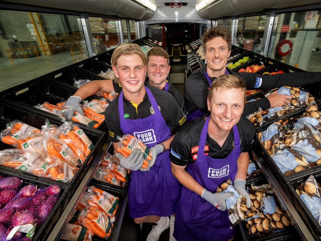 Richmond players Josh Smillie and Jacob Hopper along with Collingwood players Brody Mihocek and Will Hoskin-Elliott at Foodbank Yarraville to promote the 2025 Charity Shield match between the two clubs. Picture: Tony Gough