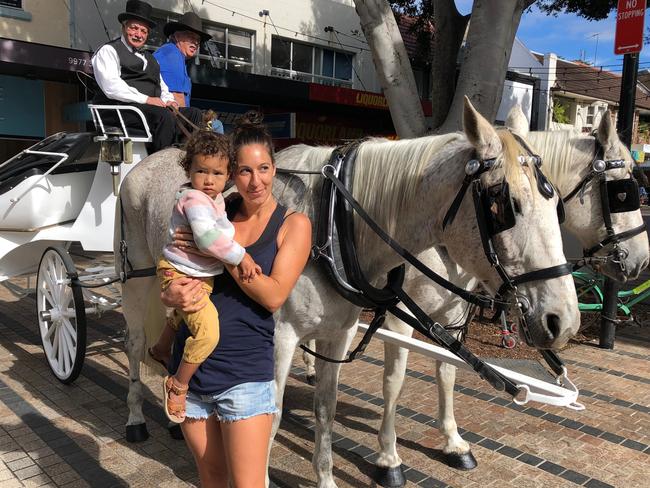 May Slater, of Fairlight, with her daughter Tula, 2, with the GetUp horses and carriage. 