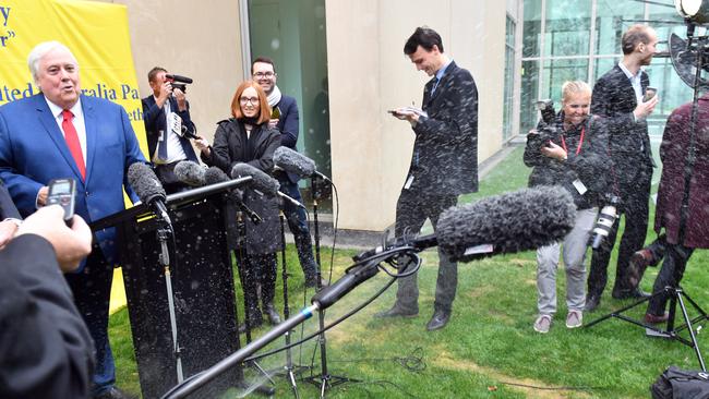 Clive Palmer leaves a press conference after a water sprinkler is turned on. Picture: AAP.