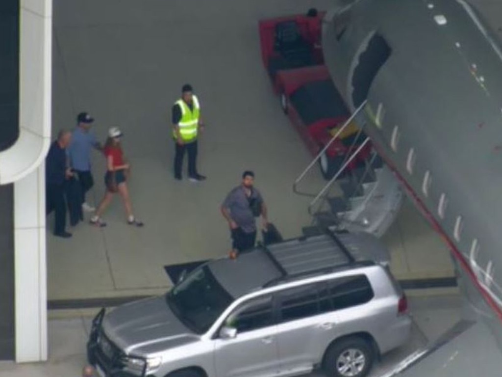 Taylor Swift (pictured in red) boards her private jet out of Melbourne on Monday 19 February, 2024. Picture: Channel 9