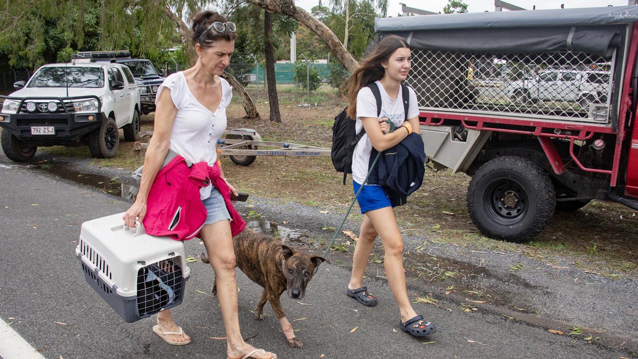 A evacuee family Stephanie Schumacher, daughter Bella and pets Otis and Ralphie arrive at the Barron River bridge north Cairns after being rescued by boats following Cyclone Jasper. Picture: NCA NewsWire / Brian Cassey