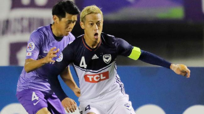 Melbourne Victory’s Keisuke Honda shields the ball from Sanfrecce Hiroshima’s Hiroki Mizumoto on Tuesday night. 