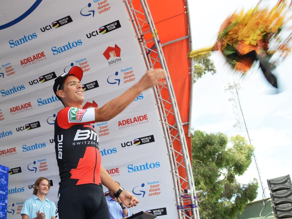 Richie Porte of Australia throws flowers into the crowd from the podium. AFP PHOTO / BRENTON EDWARDS