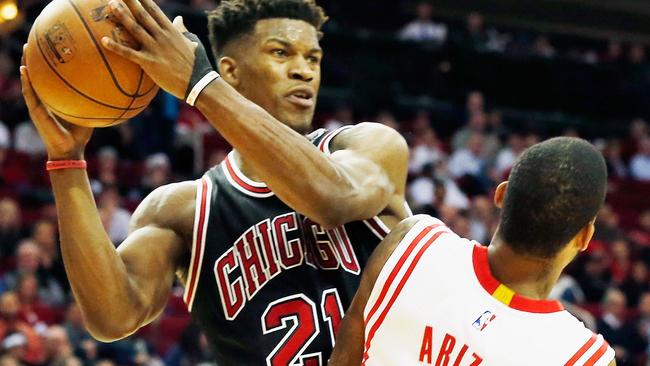 Jimmy Butler #21 of the Chicago Bulls looks to pass over Trevor Ariza #1 of the Houston Rockets.