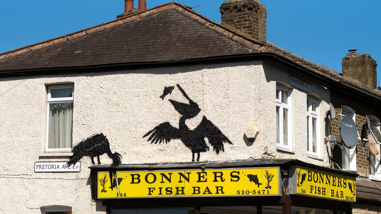 This Banksy mural cleverly shows a pelican eating fish off the sign of the shop. Picture: Matthew Baker/Getty Images