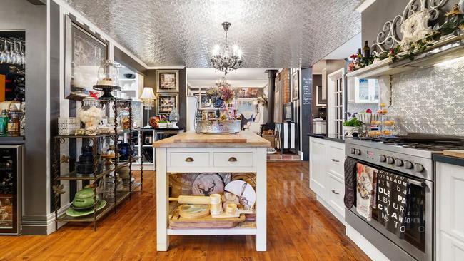 The home’s remarkable design scheme includes a glimmering pressed-metal kitchen.