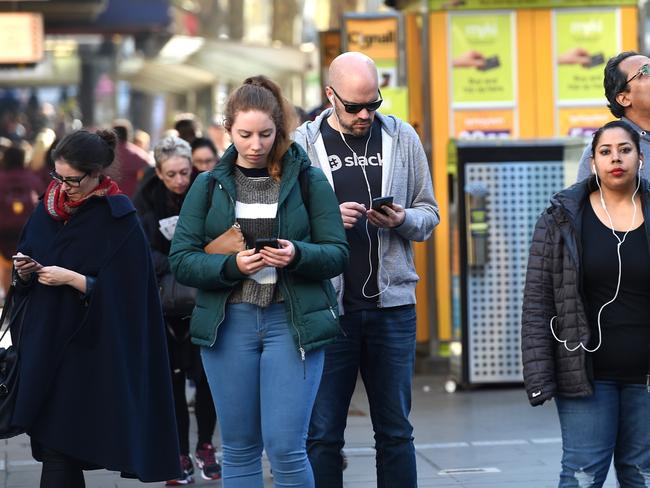 People in the city looking and listening to their phones. Picture: Nicole Garmston