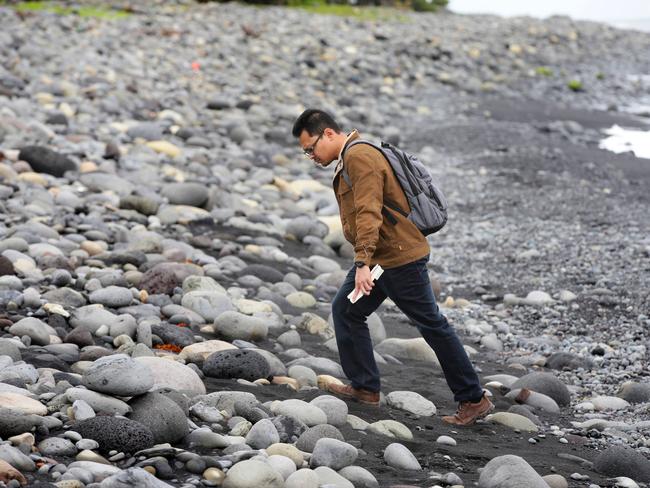 Searching ... Member of the multi national taskforce team combing Saint-Andre beach for more MH370 debris. Picture: Cameron Richardson/News Corp Australia