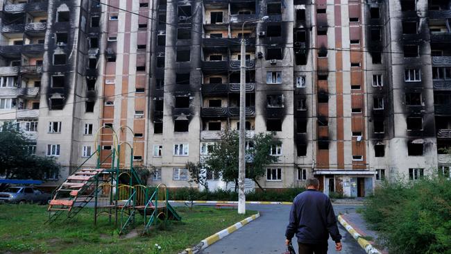 A man walks towards a damaged residential building in the town of Irpin. Ukraine said on September 11 that its forces were pushing back Russia's military from strategic holdouts in the east of the country after Moscow announced a retreat from Kyiv's sweeping counteroffensive.