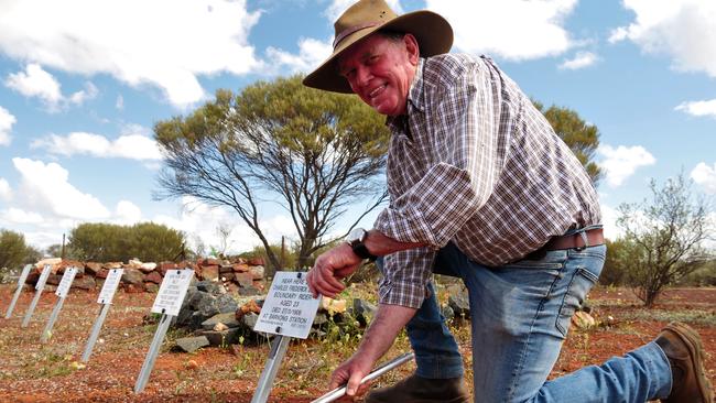 Row of plaques: Trevor Tough hard at work. The plaque he is holding is for a boundary rider who died nearby, aged 23. Pictures: Samille Mitchell