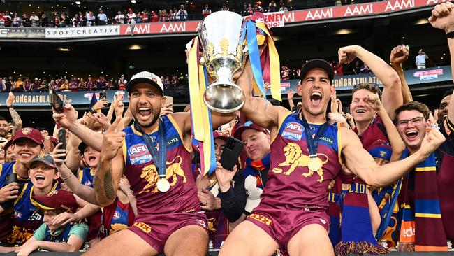 MELBOURNE, AUSTRALIA - SEPTEMBER 28: Callum Ah Chee and Brandon Starcevich of the Lions celebrate with the Premiership Cup and fans after winning the AFL Grand Final match between Sydney Swans and Brisbane Lions at Melbourne Cricket Ground, on September 28, 2024, in Melbourne, Australia. (Photo by Quinn Rooney/Getty Images)