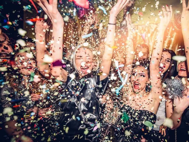 Confetti falling over a smiling group of people on a dance floor of a nightclub