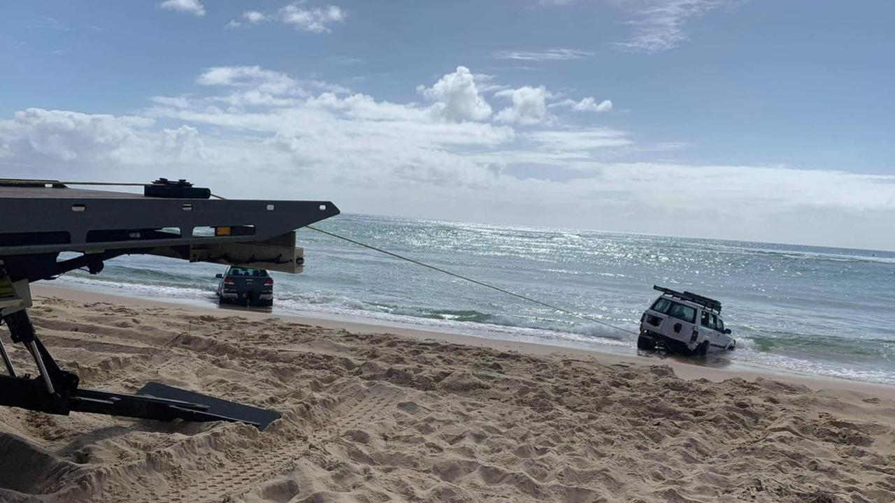 Two 4WDs were pulled out of the water at Teewah Beach on the weekend. Pictures: Clayton's Towing