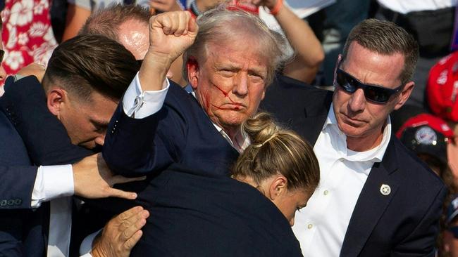 Donald Trump surrounded by secret service agent after an apparent assassination attempt. Picture: Rebecca Droke / AFP