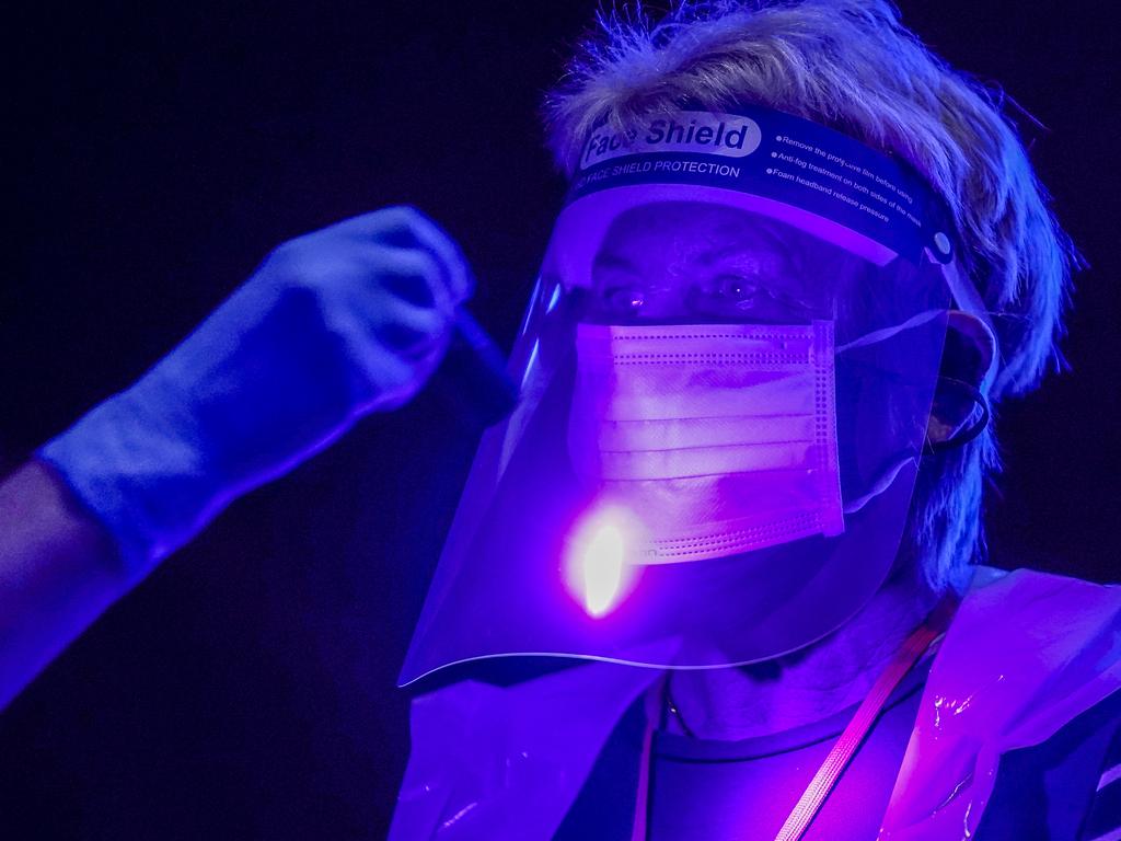 Volunteers illuminated by ultra violet light to demonstrate how contamination can spread as St John Ambulance trains them to administer COVID-19 vaccines at Manchester United Football Club in England on January 30. Picture: Christopher Furlong/Getty Images