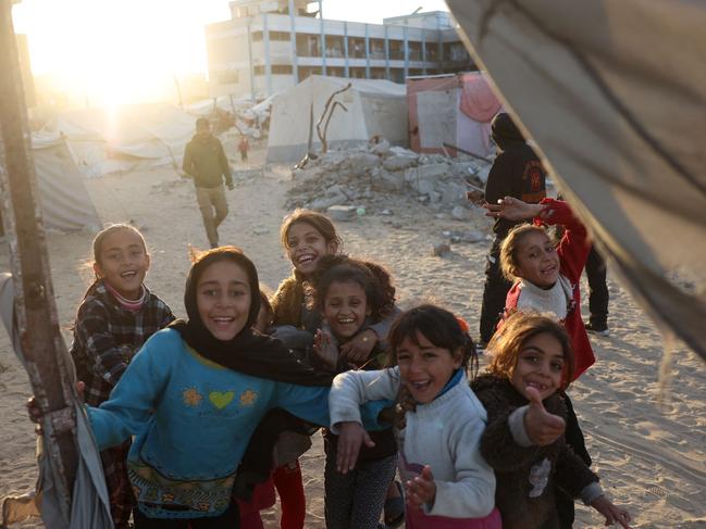 Palestinian children, displaced from their homes, smile for a picture. Israeli forces detained the director of a hospital in the north, which the World Health Organization said was put out of service by an Israeli raid. Picture: AFP