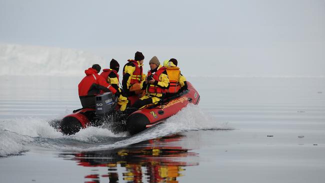 Researchers take to the waters in inflatable rubber boats (IRB's) at the edge of the fast ice where the Australian Antarctic Divisions chartered icebreaker the Aurora Australis is wedged at Commonwealth Bay 10nm from Mawson's Hut in Antarctica, Monday, Jan. 16, 2012. (AAP Image/Dean Lewins)