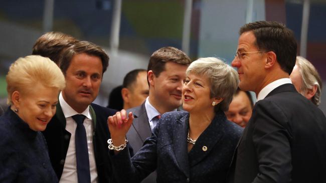 Theresa May, speaks with Dutch Prime Minister Mark Rutte, right, and Lithuanian President Dalia Grybauskaite, left, during a round table meeting at an EU summit. Picture: AP.,