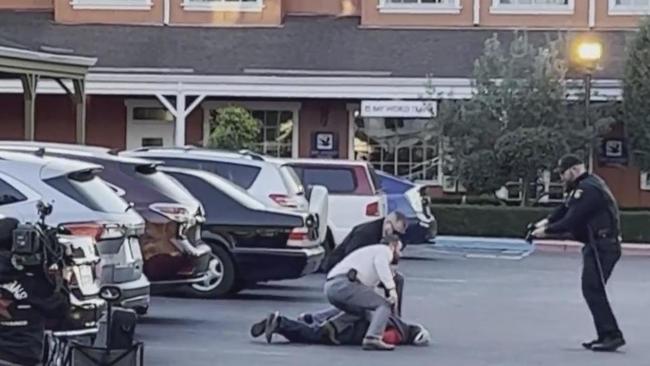 Officers take a man identified as Zhao Chunli into custody after he drove to a sheriff's office media staging area following multiple shootings in Half Moon Bay that left at least seven people dead. Picture: CBS